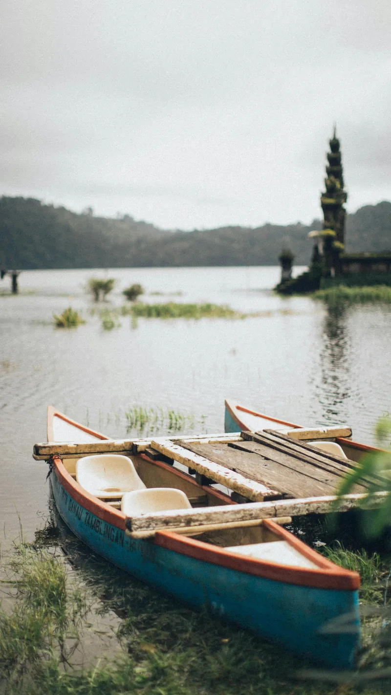 Boat on a lake in Indonesia with a temple