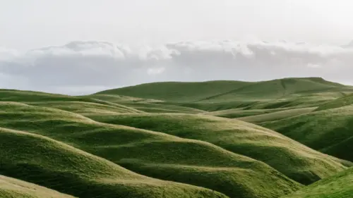 Minimalist green hill and cloudy sky in the background wallpaper HD 4K for desktop