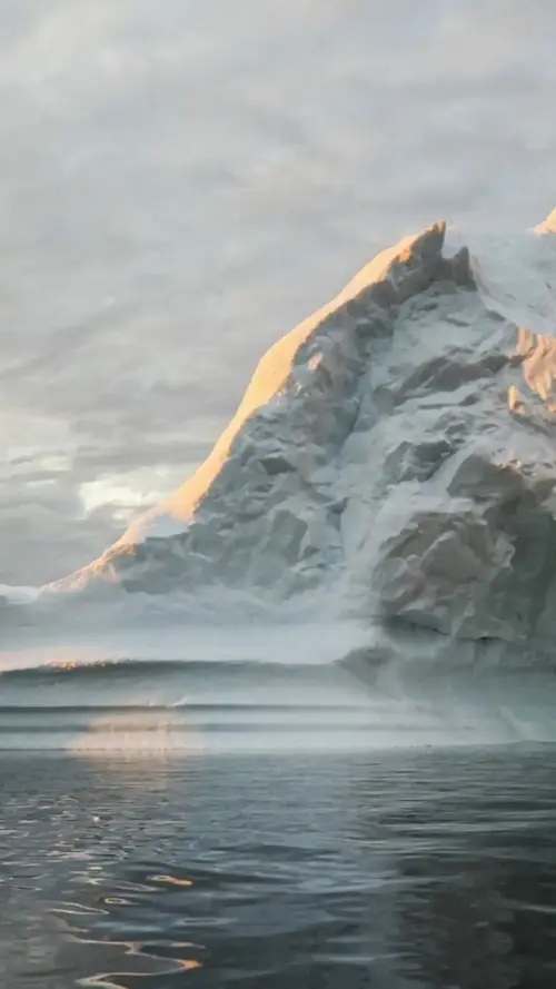 Iceberg on the Arctic Ocean and cloudy sky