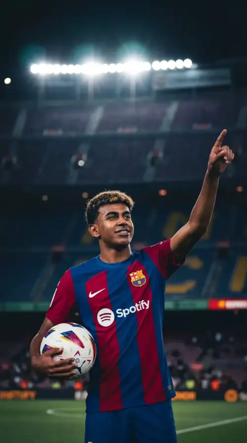Lamine Yamal of FC Barcelona holding a ball at the stadium wallpaper HD 4K for phone