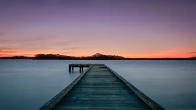 Ponton en bois sur lac au coucher du soleil