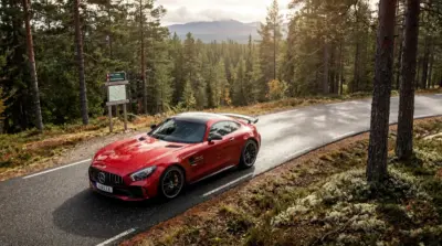 Voiture Mercedes AMG rouge en forêt