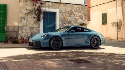 Porsche 911 Carrera GTS bleu ardoise dans un village