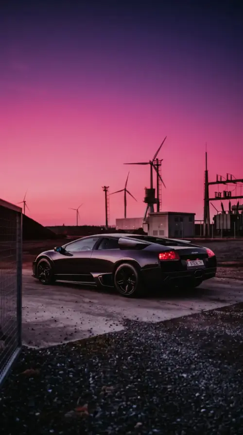 Black Lamborghini Murciélago at a purple sunset