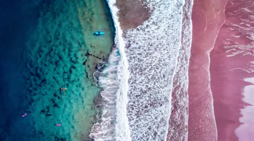 Turquoise ocean and pink beach seen from the sky