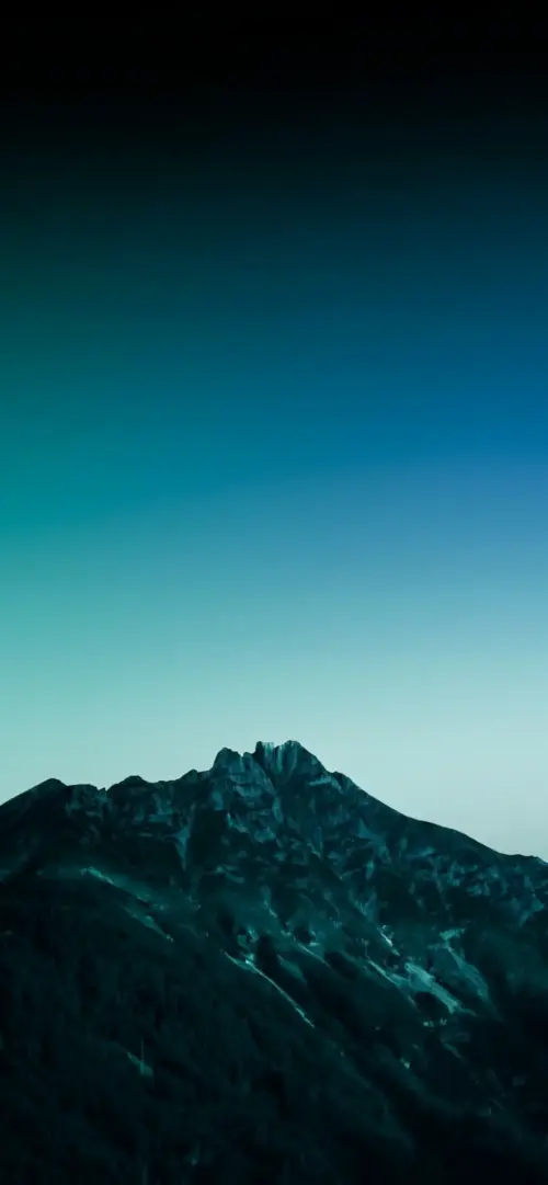 Dark mountain under a blue gradient sky