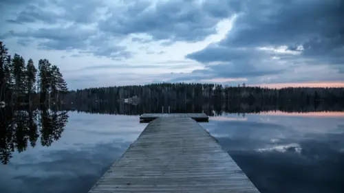 Calm lake and jetty at dusk